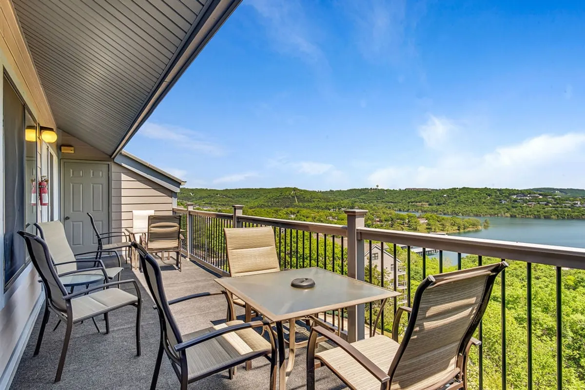 A private deck with outdoor seating and a table, overlooking the sparkling lake. The tranquil atmosphere invites relaxation, outdoor dining, and soaking in sweeping vistas any time of day.