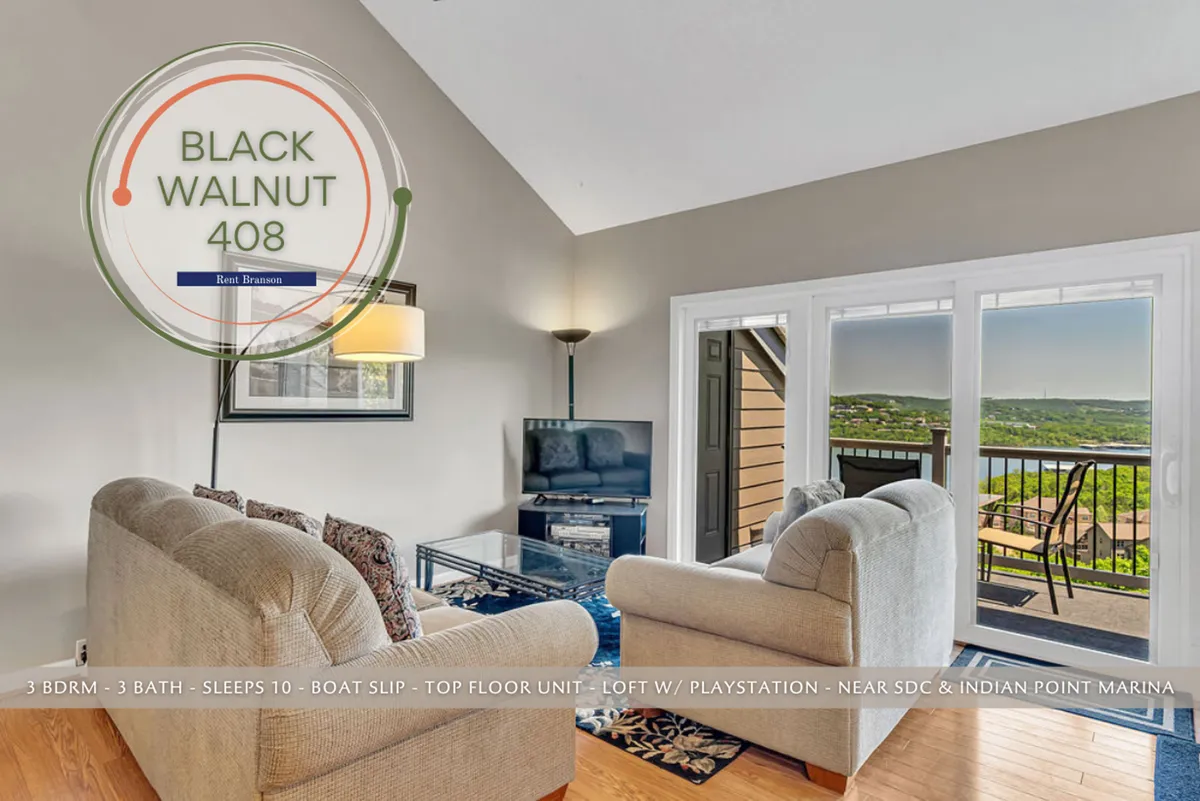 A cozy living room with a plush sofa and coffee table positioned to take in expansive views through large windows. Decorative wall art and a TV make the space inviting for both relaxation and socializing. The natural light pouring in highlights the open, airy atmosphere.