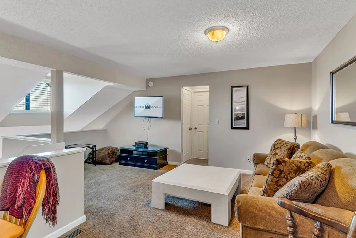 A cozy lounge area outfitted with a sofa, coffee table, and television, set up for movie nights or gaming sessions. The space feels inviting, suggesting a fun and social spot for teens or kids to hang out.